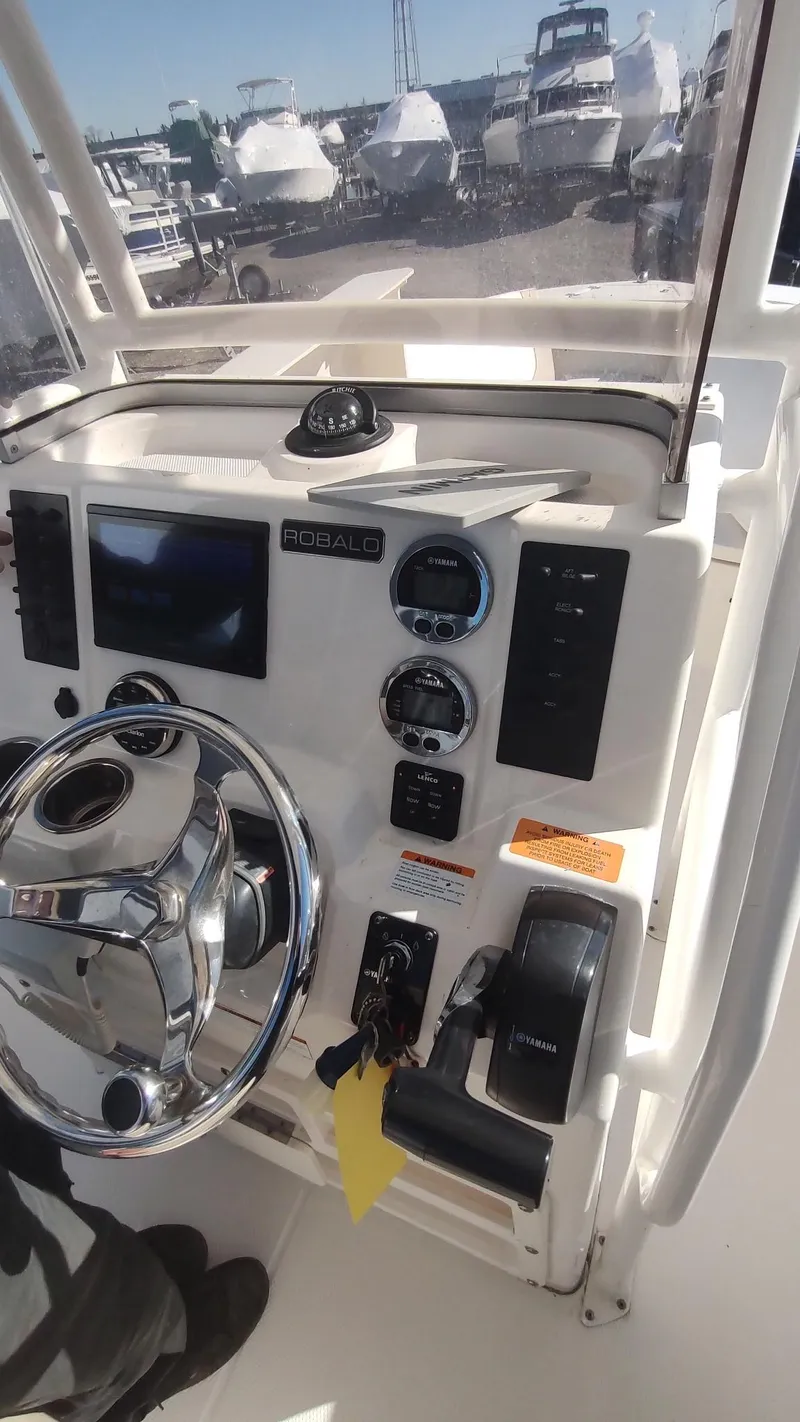 Slide: The Image of 2018 Robalo R200 Center Console boat dashboard with steering wheel and controls. - 3