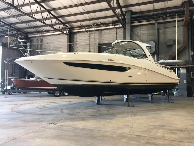 Slide: The Image of 2014 Sea Ray 370 Sundancer yacht in a spacious indoor storage facility. - 0