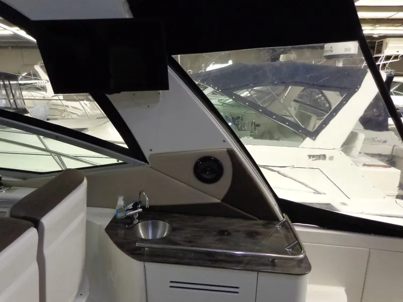 Slide: The Image of 2014 Sea Ray 370 Sundancer interior with sink and seating, showcasing luxury yacht design. - 12