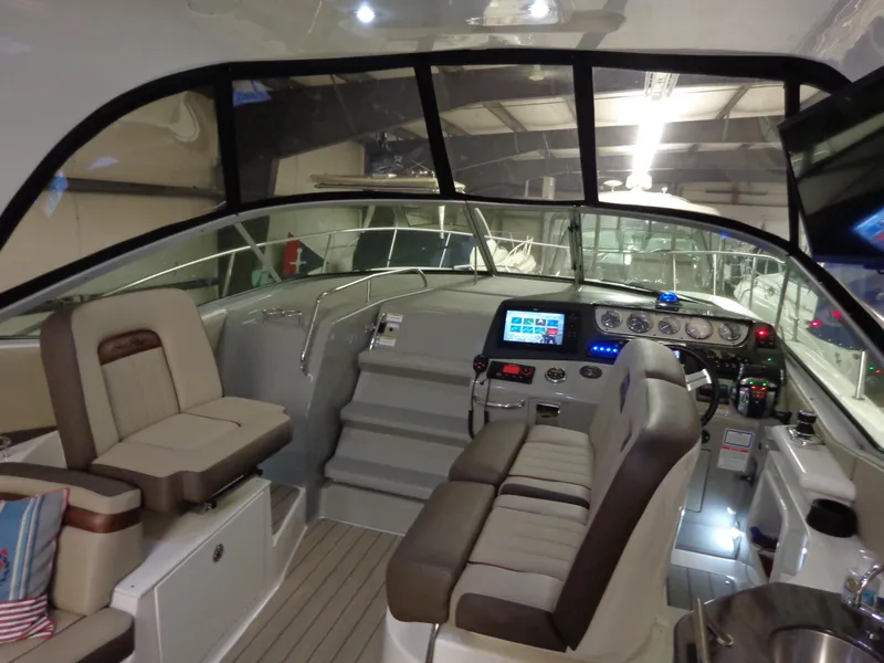 Slide: The Image of 2014 Sea Ray 370 Sundancer cockpit with modern controls and comfortable seating. - 15