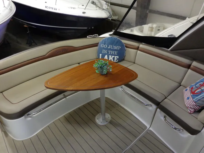 Slide: The Image of 2014 Sea Ray 370 Sundancer interior with cozy seating and wooden table. - 18