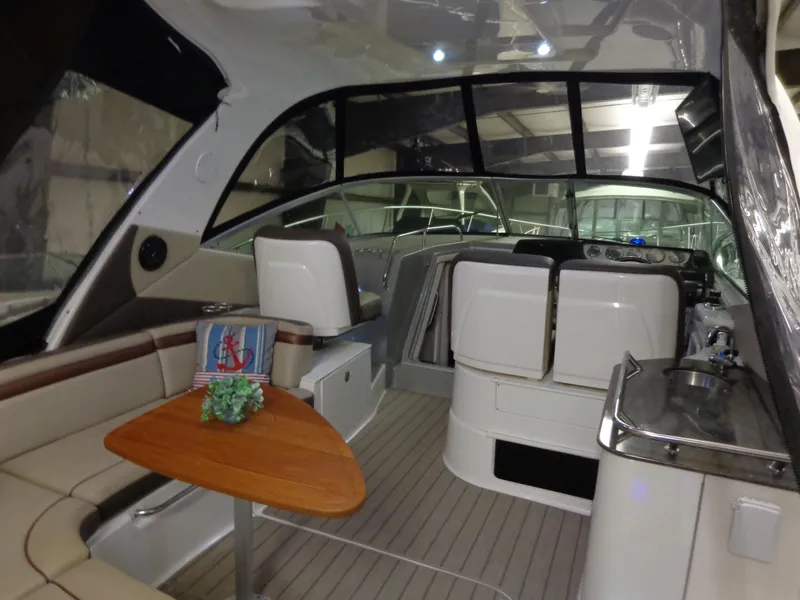 Slide: The Image of 2014 Sea Ray 370 Sundancer interior with seating, table, and helm. - 19
