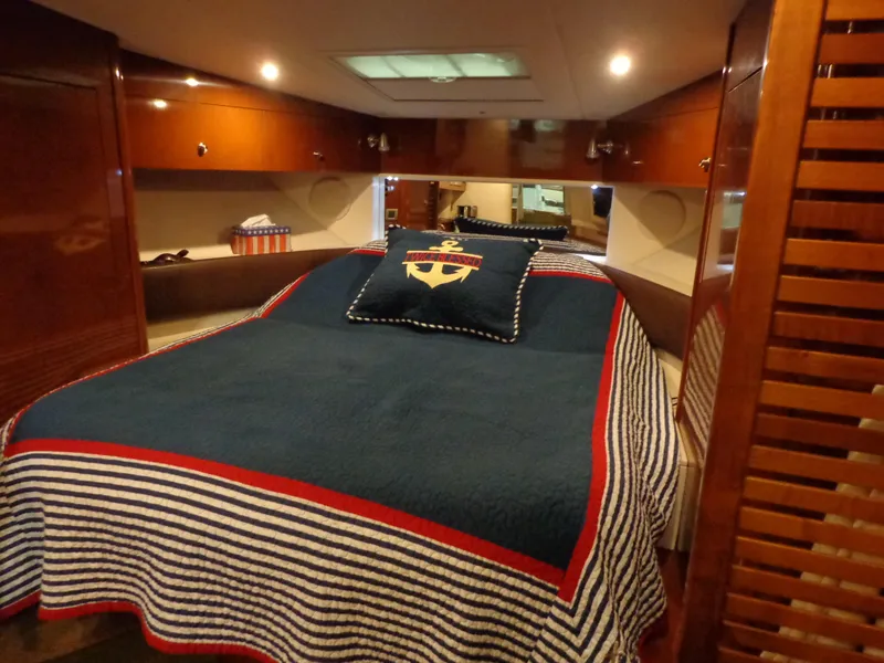 Slide: The Image of Cabin interior of 2014 Sea Ray 370 Sundancer with nautical-themed bedding. - 2