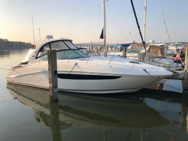 Slide: The Image of 2014 Sea Ray 370 Sundancer yacht docked in a marina, calm water reflection. - 22
