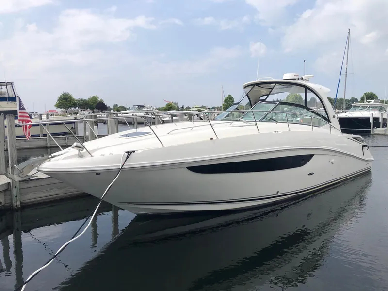 Slide: The Image of 2014 Sea Ray 370 Sundancer yacht docked in a marina, under a partly cloudy sky. - 23