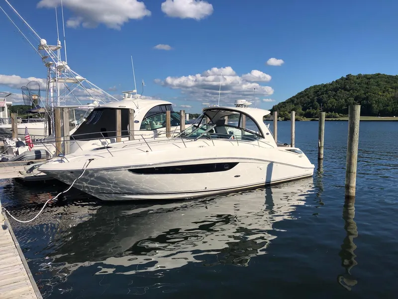 Slide: The Image of 2014 Sea Ray 370 Sundancer yacht docked in a marina under a clear blue sky. - 24