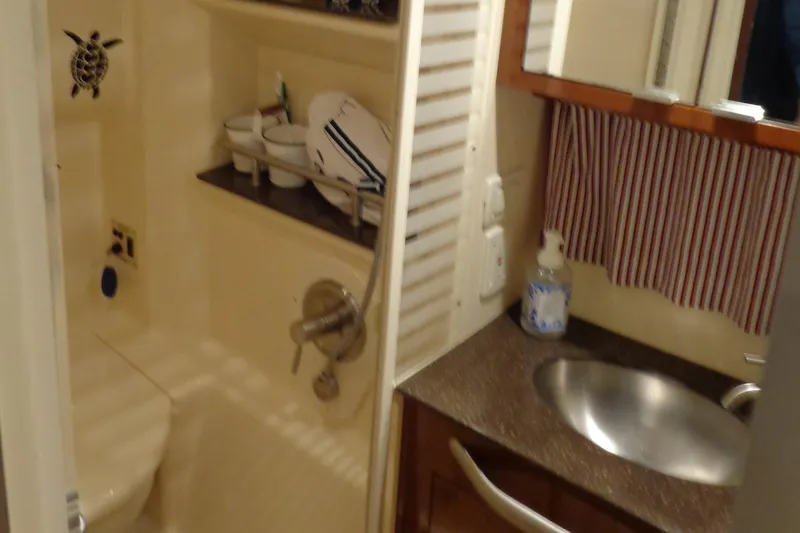 Slide: The Image of Bathroom interior of 2014 Sea Ray 370 Sundancer yacht, featuring sink and storage shelves. - 29