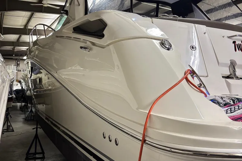 Slide: The Image of 2014 Sea Ray 370 Sundancer yacht in storage, showcasing sleek design and white exterior. - 33