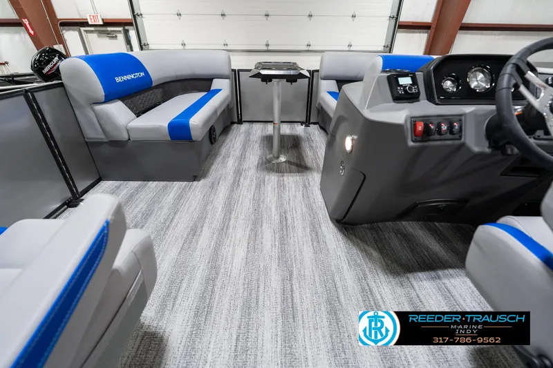 Slide: The Image of 2025 Bennington 20 SSB pontoon boat interior with gray and blue seating, modern dashboard, and carpeted flooring. - 20