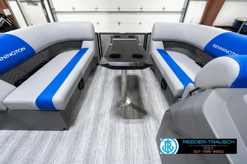 Slide: The Image of 2025 Bennington 20 SSB boat interior with gray and blue seating, central table, and carpeted floor. - 21
