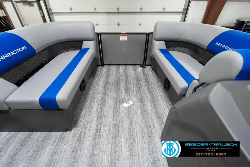 Slide: The Image of 2025 Bennington 20 SSB interior with gray and blue seating, displayed in a showroom. - 22