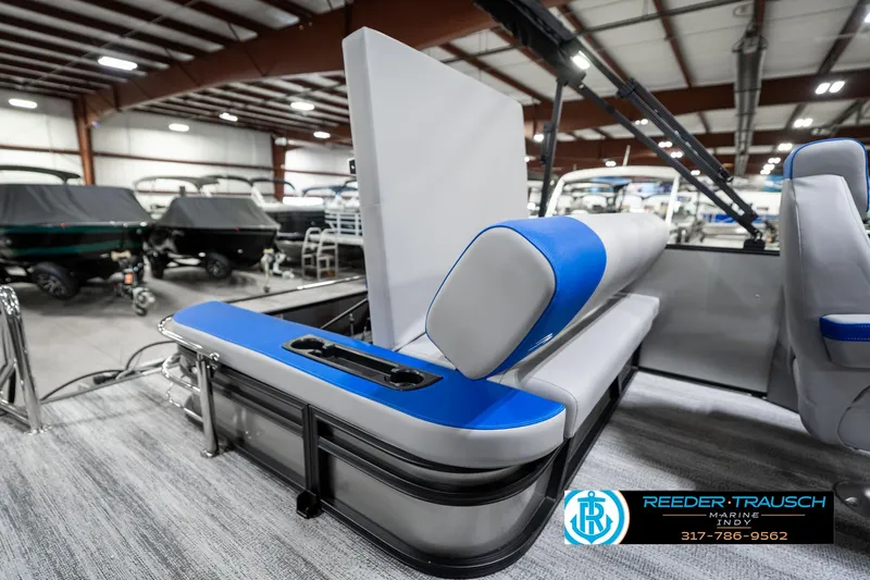 Slide: The Image of 2025 Bennington 20 SSB pontoon boat interior with blue and gray seating in showroom. - 25