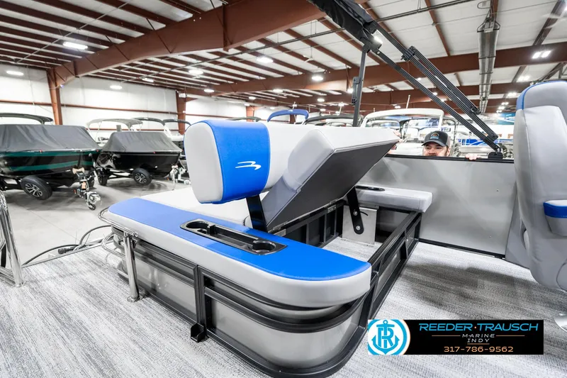 Slide: The Image of 2025 Bennington 20 SSB pontoon boat interior with blue and white seating in showroom. - 27