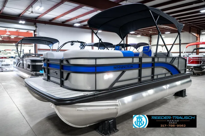 Slide: The Image of 2025 Bennington 20 SSB pontoon boat in showroom, featuring sleek design and blue accents. - 3