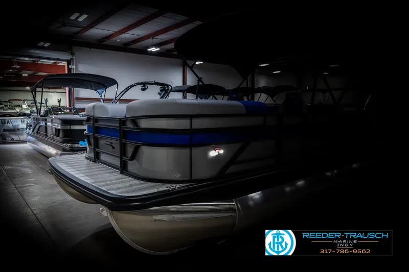 Slide: The Image of 2025 Bennington 20 SSB pontoon boat in showroom, side view, low lighting. - 4