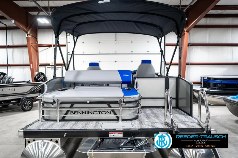Slide: The Image of 2025 Bennington 20 SSB pontoon boat in showroom, featuring spacious seating and canopy. - 9