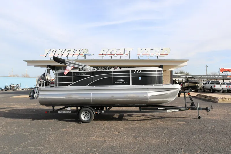 Slide: The Image of 2021 Bennington SX 20 Quad Bench pontoon boat on trailer at dealership. - 0