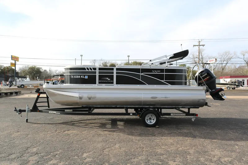 Slide: The Image of 2021 Bennington SX 20 Quad Bench pontoon boat on trailer, parked outdoors. - 3