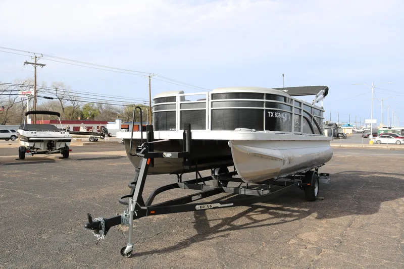 Slide: The Image of 2021 Bennington SX 20 Quad Bench pontoon boat on trailer in parking lot. - 4
