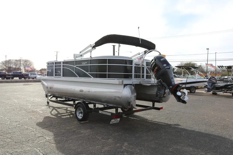 Slide: The Image of 2021 Bennington SX 20 Quad Bench pontoon boat on trailer, outdoor setting. - 5