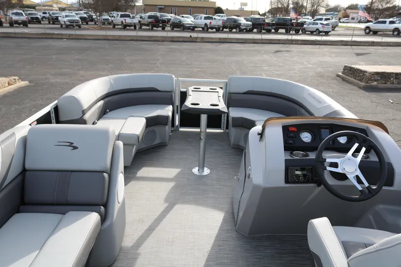 Slide: The Image of 2021 Bennington SX 20 Quad Bench pontoon boat interior with gray seating and steering console. - 7
