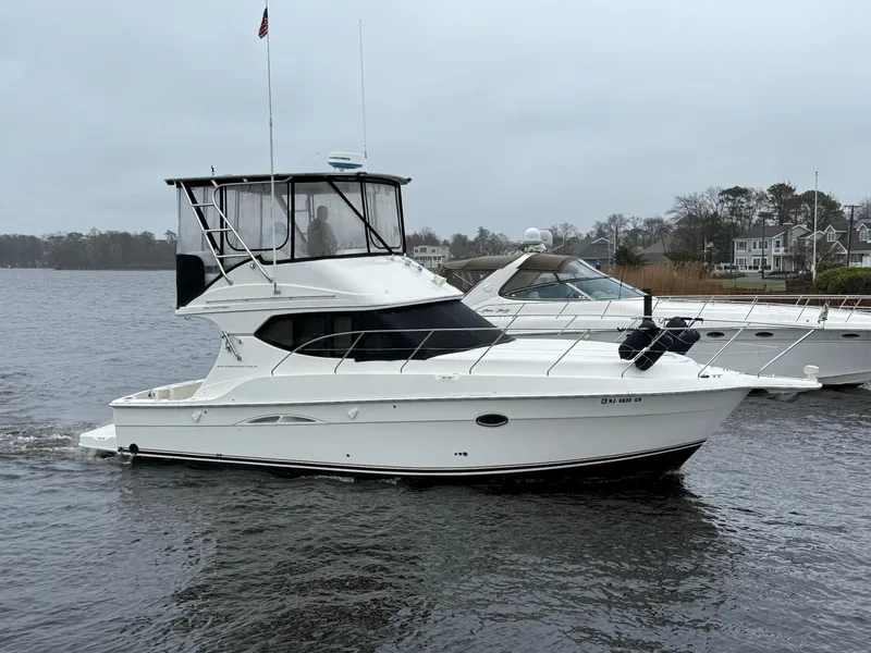 Slide: The Image of 2004 Silverton 34 Convertible yacht cruising on a calm, overcast waterway. - 0