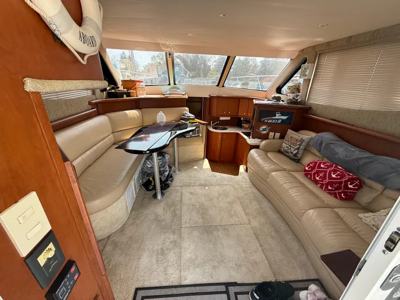 Slide: The Image of Interior of 2004 Silverton 34 Convertible yacht with beige seating and wooden accents. - 10