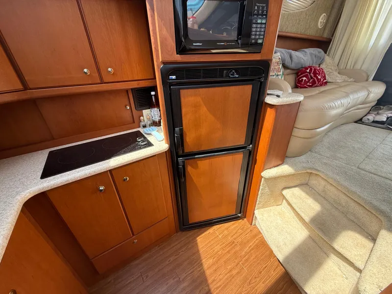 Slide: The Image of 2004 Silverton 34 Convertible yacht interior with kitchenette, fridge, and cozy seating area. - 15