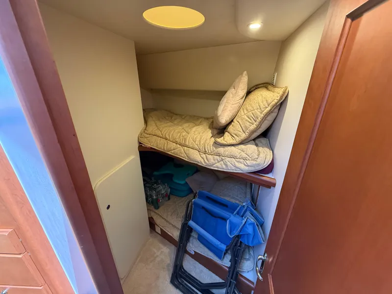 Slide: The Image of 2004 Silverton 34 Convertible cabin with bunk bed and storage items. - 16
