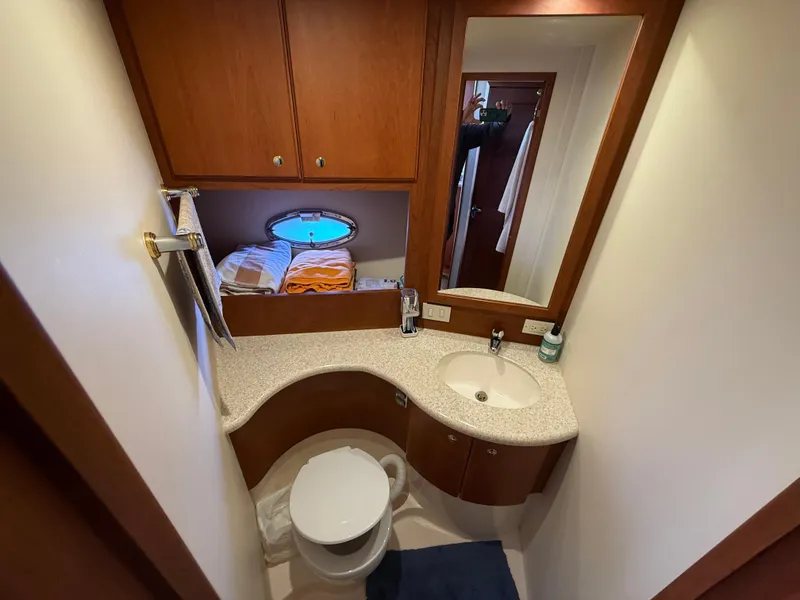 Slide: The Image of 2004 Silverton 34 Convertible yacht bathroom with sink, toilet, and wooden cabinetry. - 17