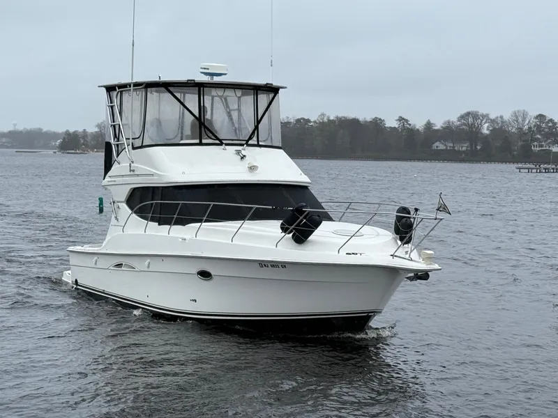 Slide: The Image of 2004 Silverton 34 Convertible yacht cruising on a calm lake. - 2