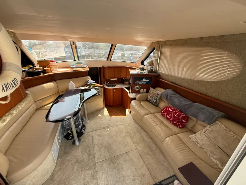 Slide: The Image of Interior of 2004 Silverton 34 Convertible yacht with beige seating and panoramic windows. - 22