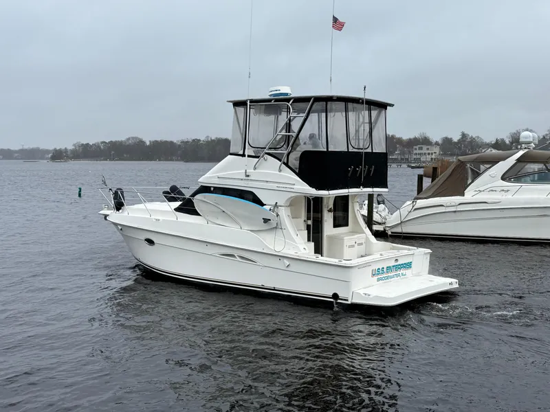 Slide: The Image of 2004 Silverton 34 Convertible boat on a calm lake with overcast skies. - 25