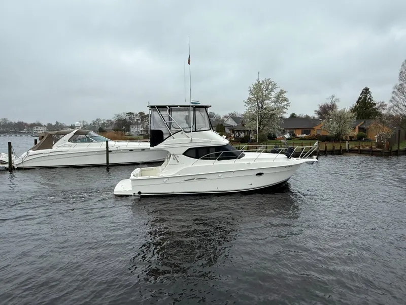 Slide: The Image of 2004 Silverton 34 Convertible yacht on a calm river, overcast sky. - 26