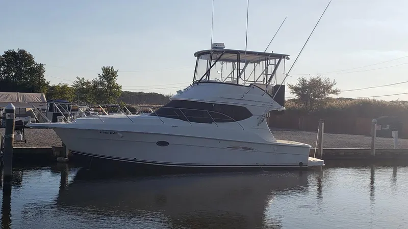 Slide: The Image of 2004 Silverton 34 Convertible yacht docked in a serene marina setting. - 27