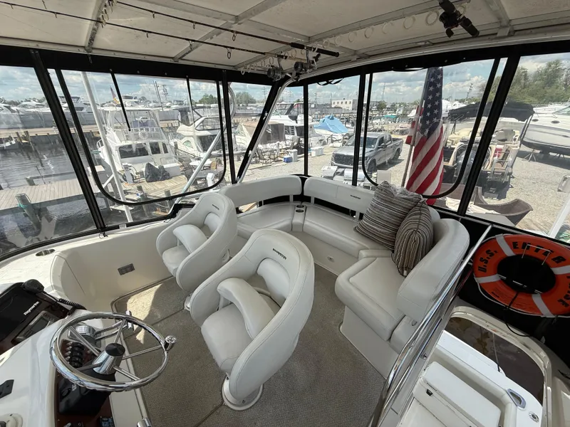Slide: The Image of 2004 Silverton 34 Convertible boat interior with helm, seating, and American flag. - 5