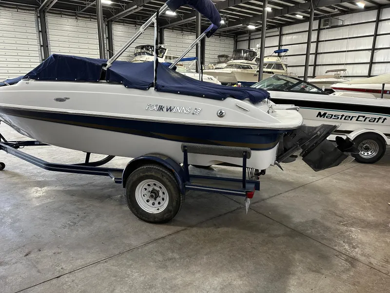 Slide: The Image of 2003 Four Winns 180 Horizon boat on trailer in indoor storage facility. - 4