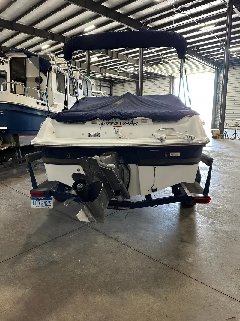Slide: The Image of 2003 Four Winns 180 Horizon boat in storage, rear view with cover and trailer. - 5