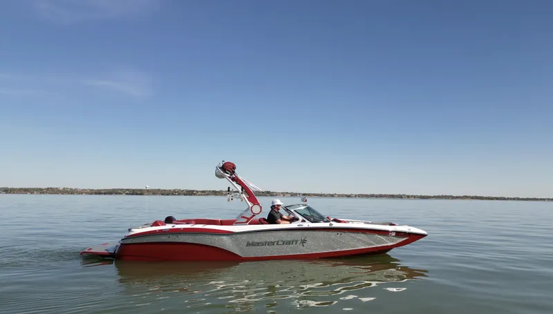 Slide: The Image of 2019 MasterCraft X46 boat on calm water under clear blue sky. - 1