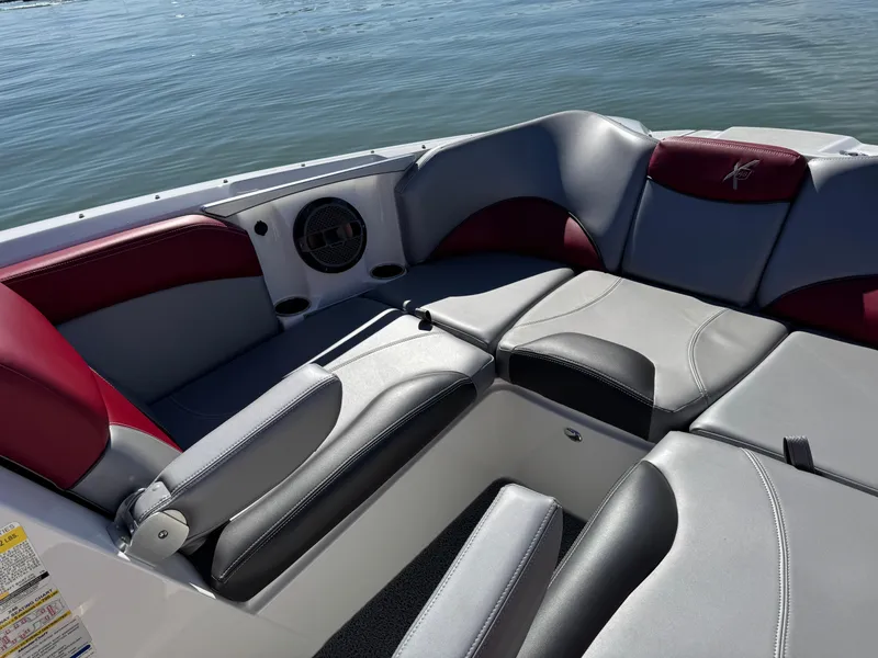 Slide: The Image of 2019 MasterCraft X46 boat interior with red and gray seating, on calm water. - 15