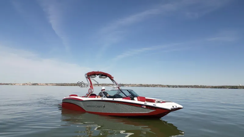 Slide: The Image of 2019 MasterCraft X46 boat on calm water under clear blue sky. - 2