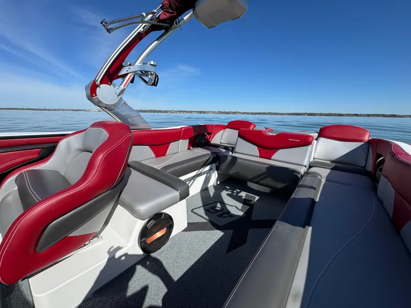 Slide: The Image of 2019 MasterCraft X46 boat interior with red and gray seating on a sunny day. - 25