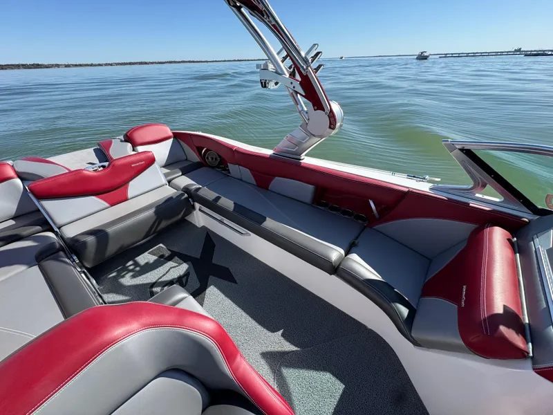 Slide: The Image of 2019 MasterCraft X46 boat interior with red and gray seating on a sunny day. - 26