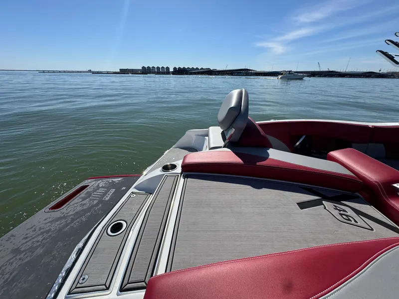 Slide: The Image of 2019 MasterCraft X46 boat on calm water, featuring red and gray seating. - 31