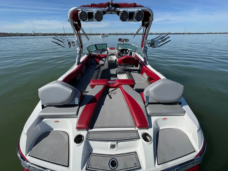 Slide: The Image of 2019 MasterCraft X46 boat with red and gray interior on calm water. - 32