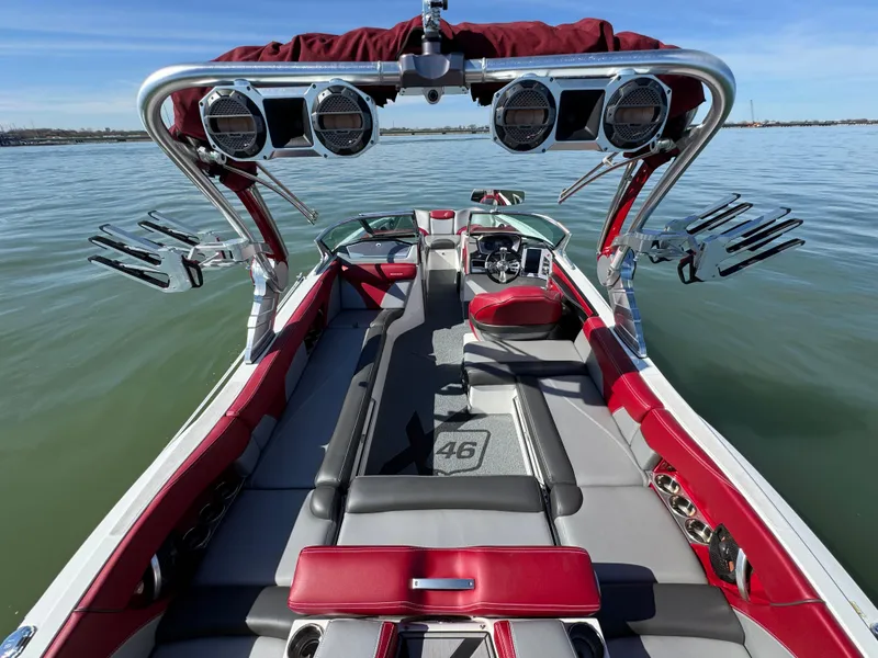 Slide: The Image of 2019 MasterCraft X46 boat interior with red and gray seating, on calm water. - 33