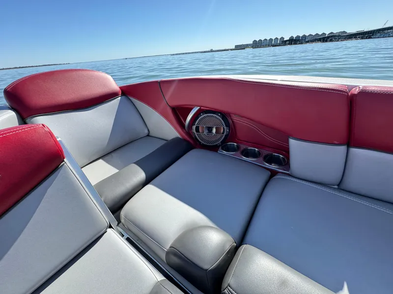Slide: The Image of 2019 MasterCraft X46 boat interior with red and gray seating, cup holders, and speaker. - 36