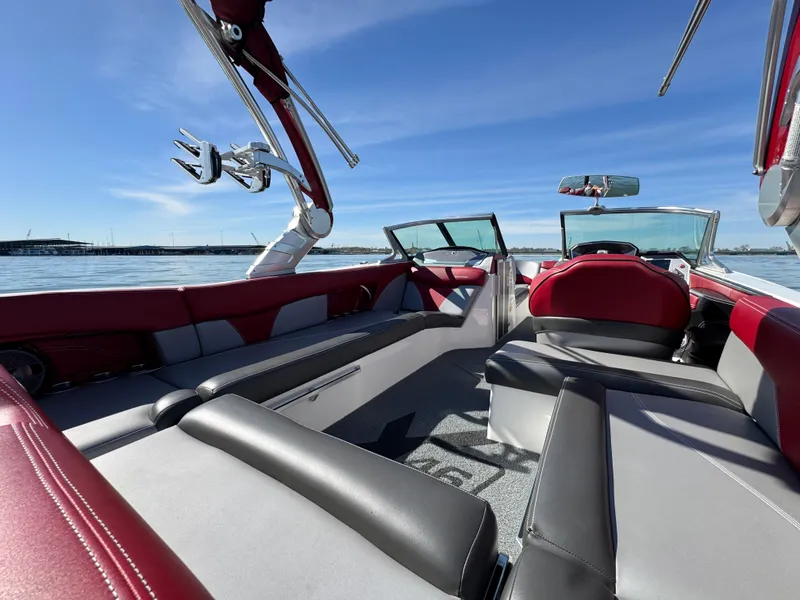 Slide: The Image of 2019 MasterCraft X46 boat interior with red and gray seating, on a sunny day. - 37
