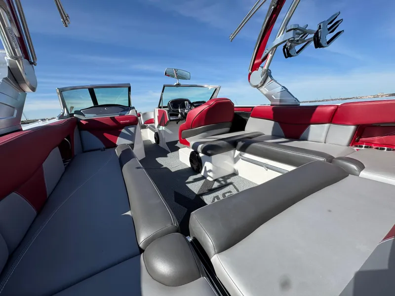 Slide: The Image of 2019 MasterCraft X46 boat interior with red and gray seating, open sky view. - 38