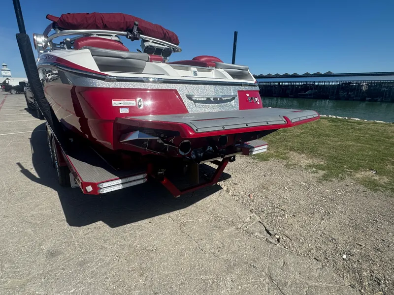 Slide: The Image of 2019 MasterCraft X46 boat with red and white design, parked near a waterfront. - 7